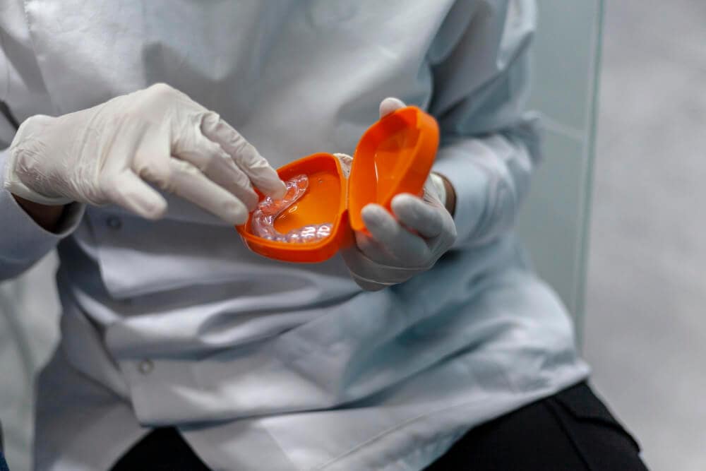 Dentist showing a custom sports mouthguard made from a dental impression