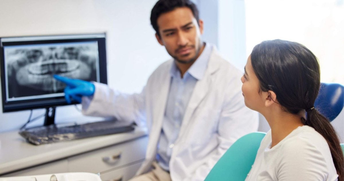 Dentist reviewing X-ray before tooth extraction in Thornton