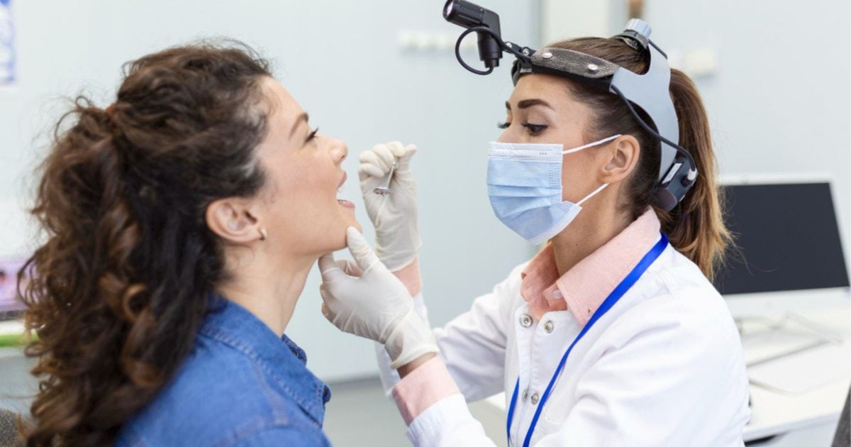 Dentist examining a mouth ulcer that has not healed in Thornton